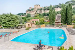 Camping Le Capeyrou - Pool mit Liegestühlen und Sonnenschirmen auf dem Campingplatz