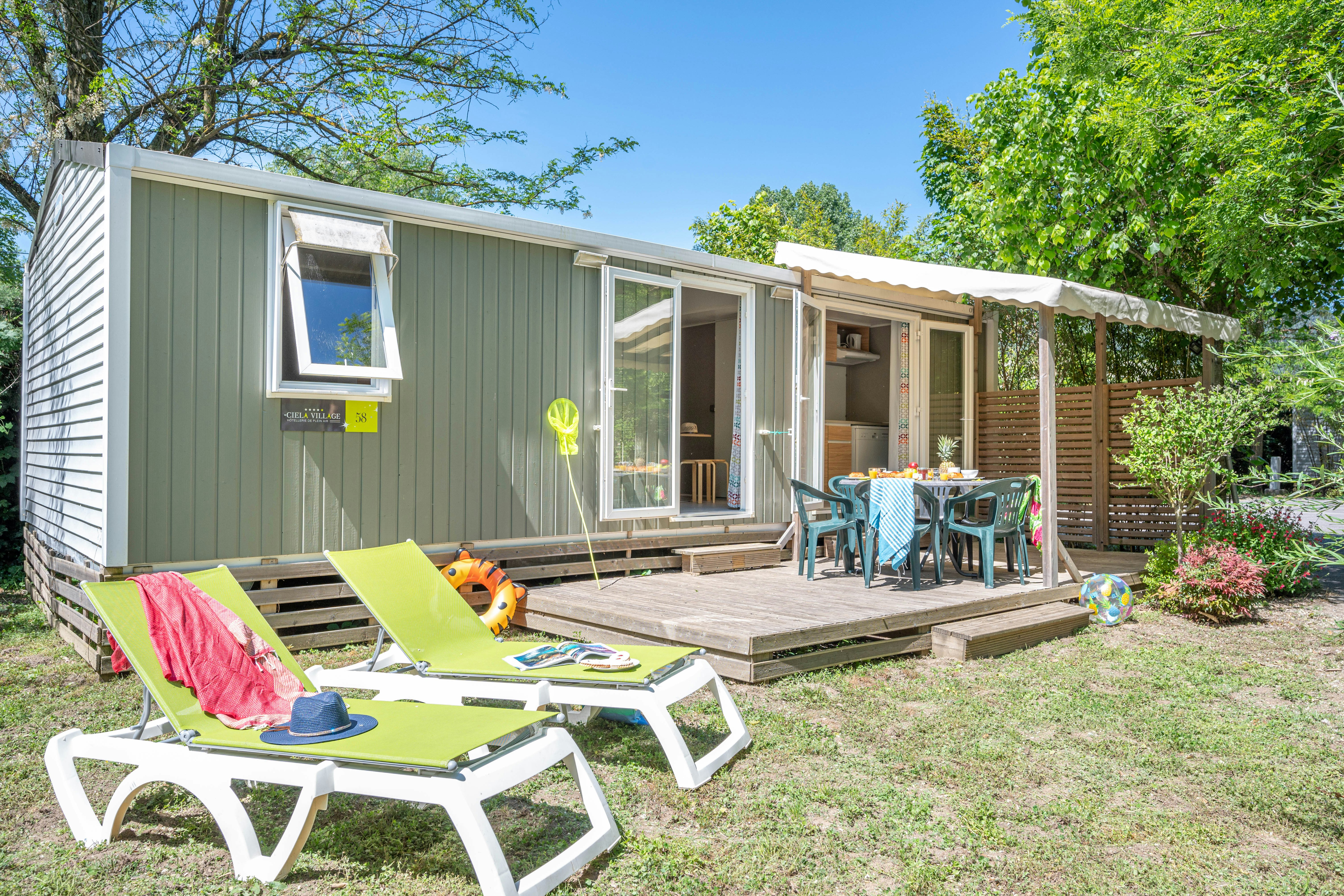 Le Castel Rose - Ciela Village  Yelloh! Village Le Castel Rose - Mobilheim mit Terrasse und Liegestühlen auf dem Campingplatz
