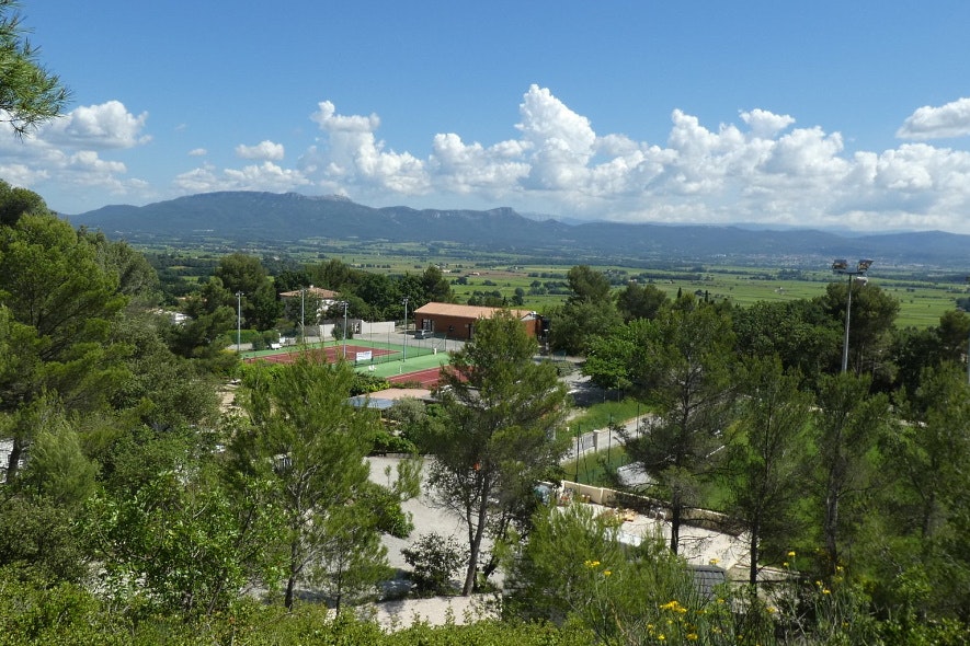 Camping Le Cezanne  Camping de Puyloubier - Ausblick vom Berg auf die Sportanlagen, weiter Blick ins Tal und auf die Berge am Horizont