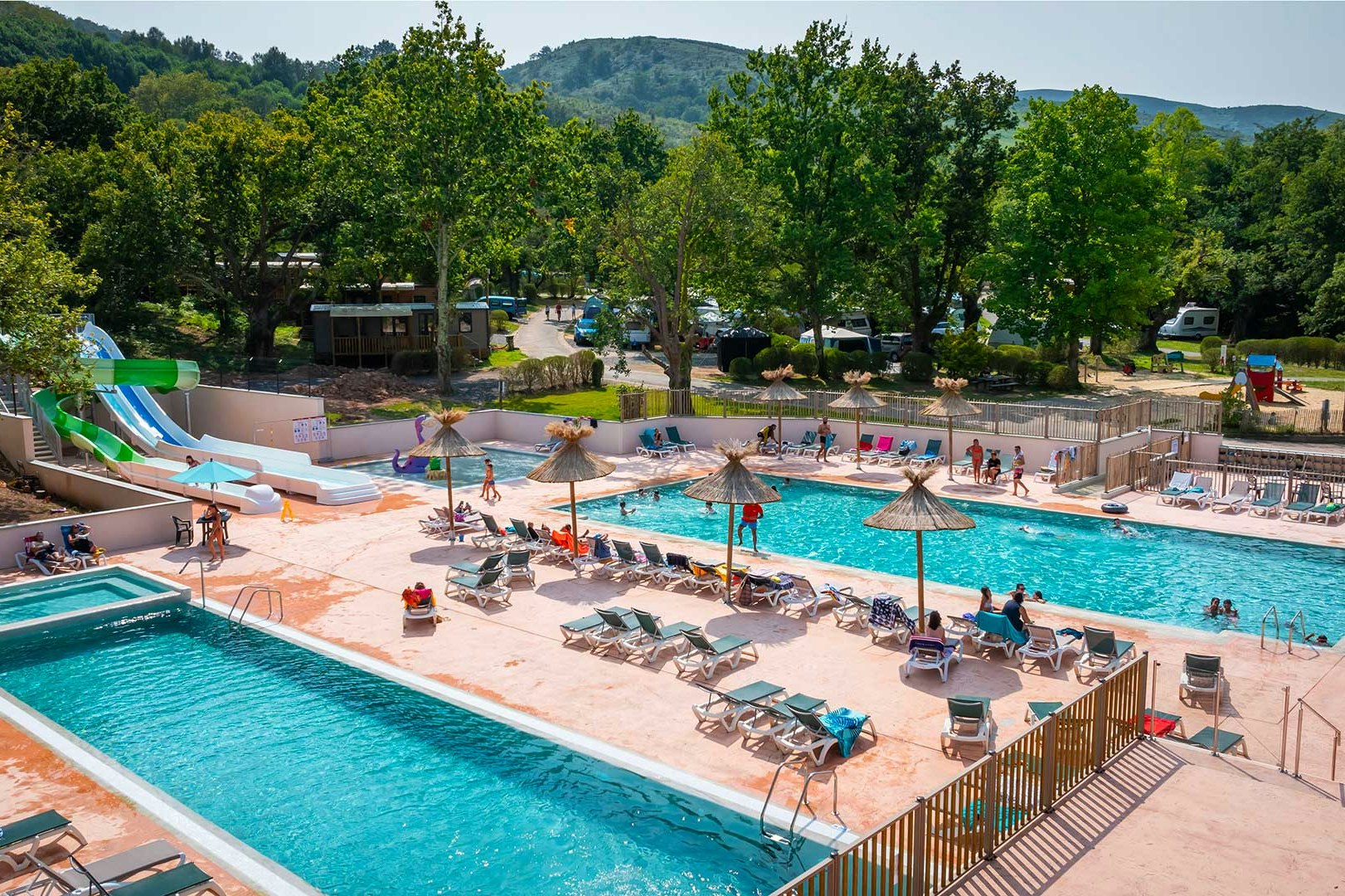 Camping Le Col d'Ibardin - Blick auf den Pool mit Liegestühlen und Sonnenschirmen