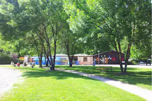 Camping Le Colombier- Gäste auf der Wiese im Schatten der Bäume