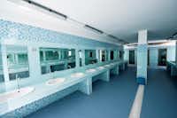 Camping Le Diomedee - Innenraum des Sanitärgebäudes mit Waschbecken und Spiegeln