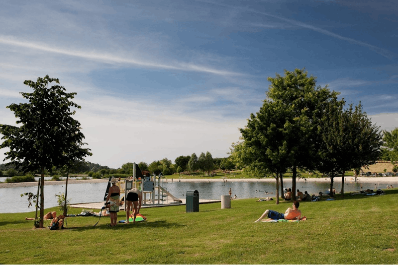 Camping Le Domaine de Louvarel  - Liegewiese und Spielplatz am See Ruisseau de l'Étang de Semon  vom Campingplatz