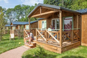 Yelloh! Village Le Fayolan - Camper auf der Veranda vom Mobilheim auf dem Campingplatz im Grünen