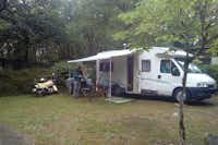 Camping Au Bois Dormant - Wohnwagen mit Markise auf dem schattigen Stellplatz vom Campingplatz