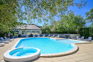 Camping Le Fondespierre - Freibad mit Liegestühlen auf dem Campingplatz