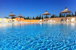 Camping Le Fun - Pool mit Liegestühlen und Sonnenschirmen auf dem Campingplatz