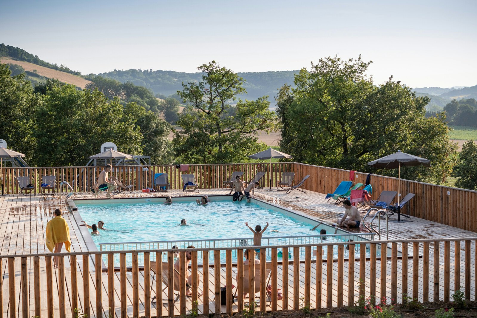 Huttopia Pays de Cordes-sur-Ciel  - Pool im Freien mit Liegestühlen und Sonnenschirmen