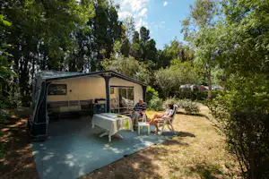 Camping Le Haras - Wohnmobilstellplatz zwischen Bäumen auf dem Campingplatz
