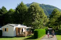 Camping Le Hounta  - Camper mit Hund bei einem Spaziergang und Mobilheim vom Campingplatz mit Blick auf die Pyrenäen