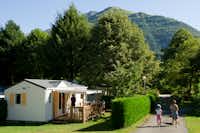Camping Le Hounta  - Camper mit Hund bei einem Spaziergang und Mobilheim vom Campingplatz mit Blick auf die Pyrenäen
