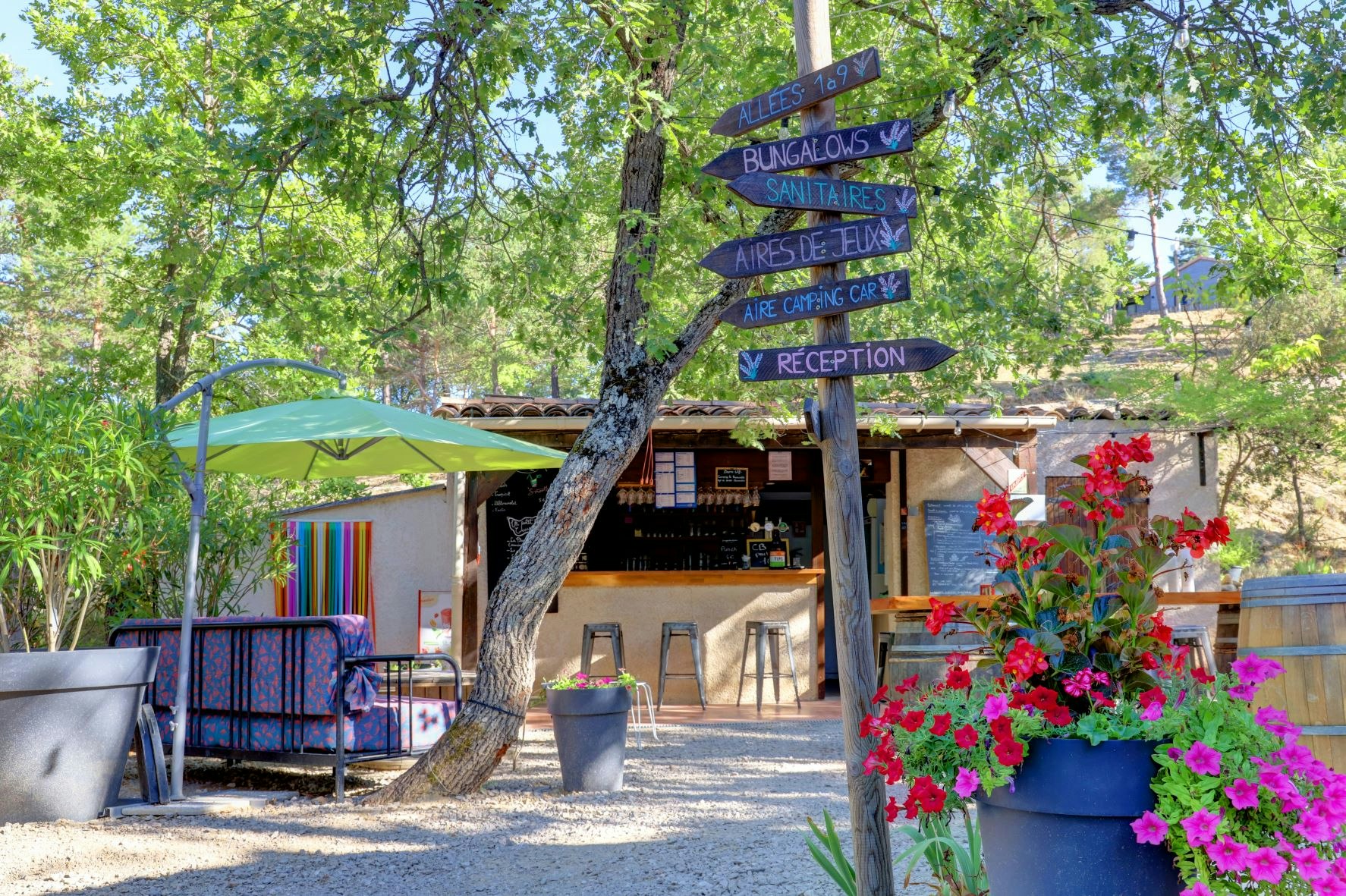 Camping Le Lavandin - Blick auf den Wegweiser und die Bar auf dem Campingplatz
