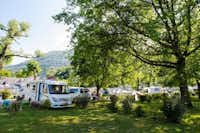 Yelloh! Village Le Lavedan  -  Stellplatz vom Campingplatz auf grüner Wiese zwischen Bäumen