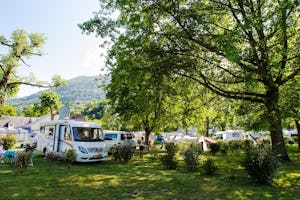 Yelloh! Village Le Lavedan - Stellplatz vom Campingplatz auf grüner Wiese zwischen Bäumen