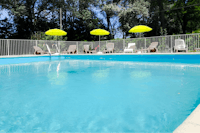 Camping Le Lion - Swimmingpool mit Liegestühlen und Sonnenschirmen
