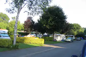 Camping Le Manoir de Pen-ar-Steir -Wohnwagen auf Stellplätzen an einer Strasse des Campingplatzes