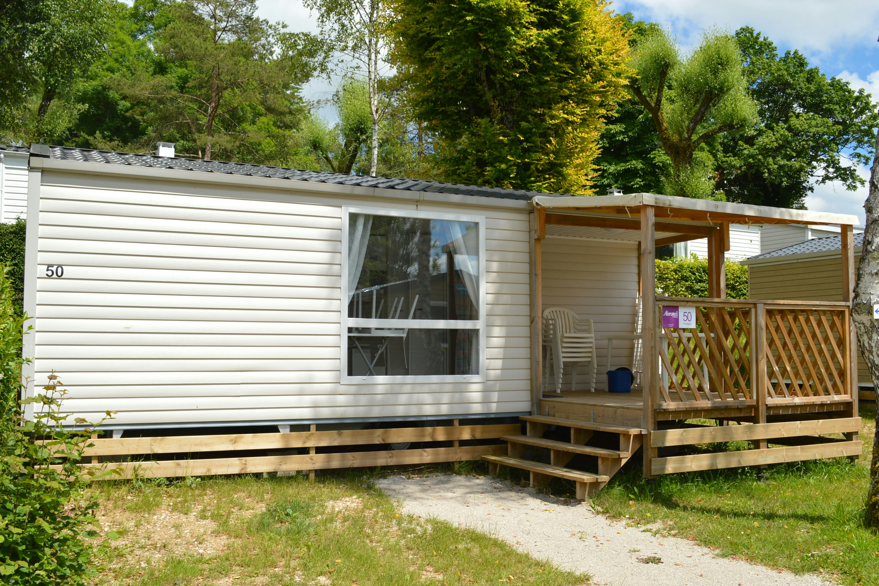 Camping Le Moulin - Eingang ins Mobilheim mit Veranda im Grünen auf dem Campingplatz