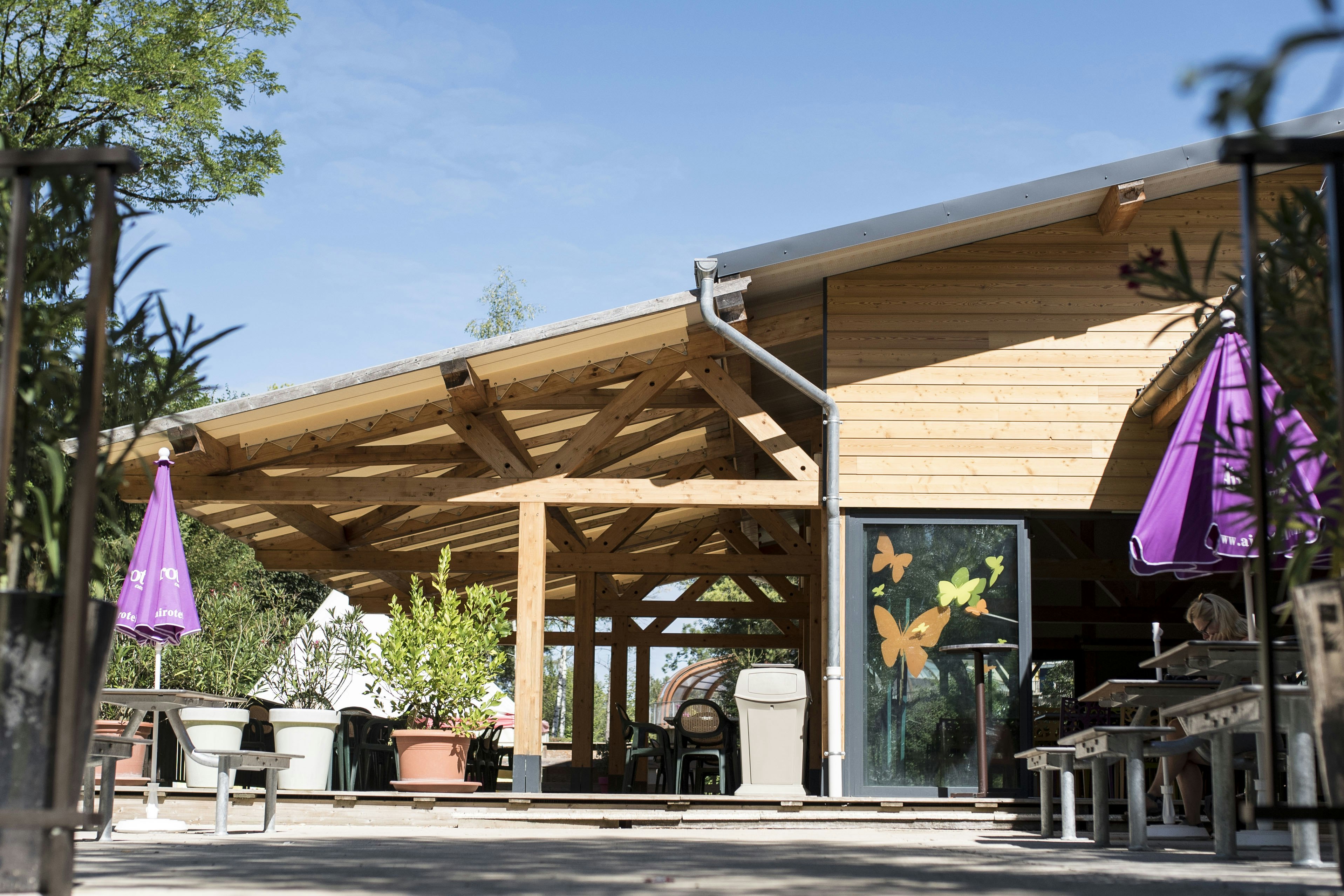 Camping Le Moulin - Restaurant mit offener Veranda und Sonnenschirmen auf dem Campingplatz