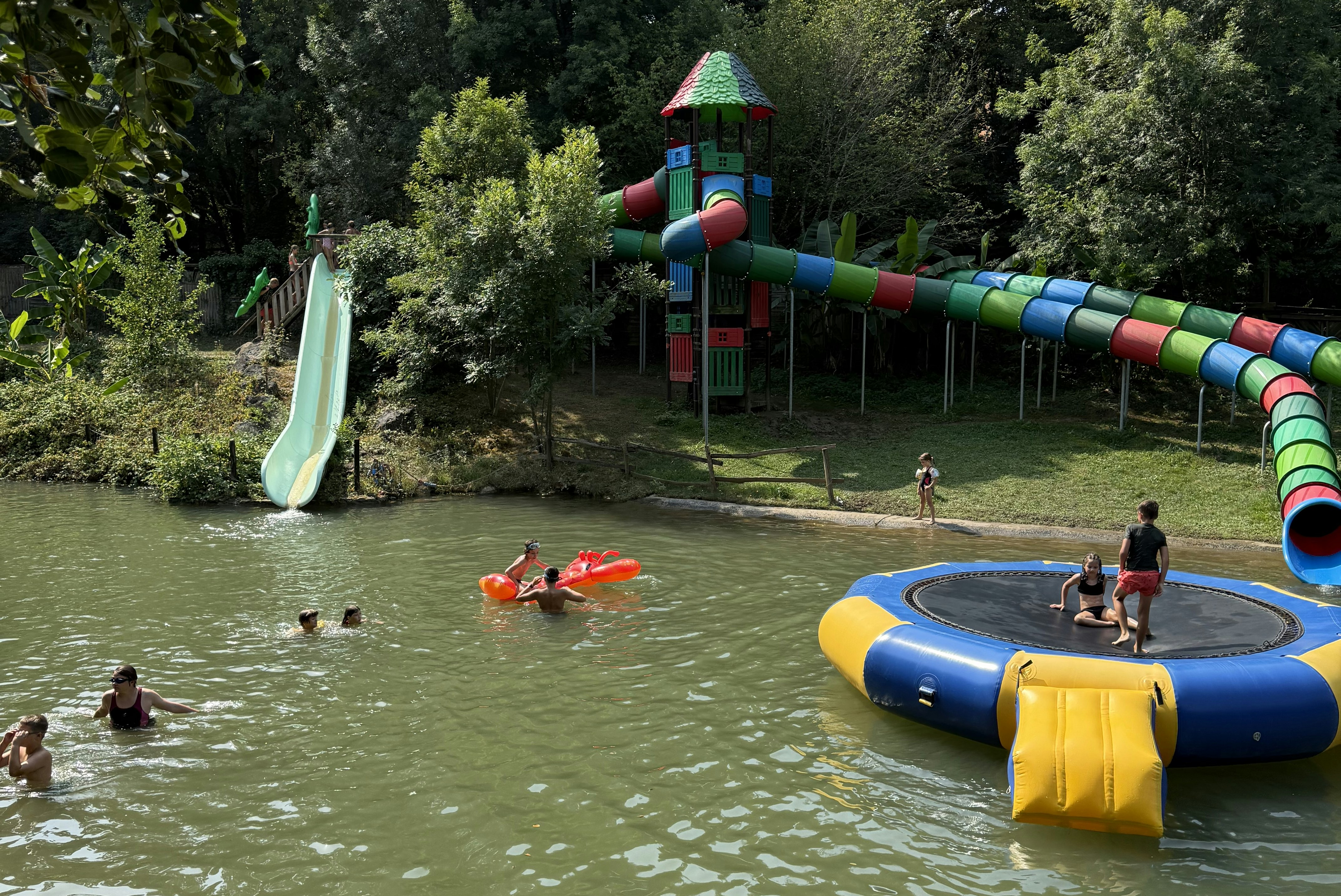 Camping Le Moulin de David - Blick auf den Badesee mit Rutschen und Spielinsel