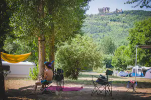 Camping le Moulin de la Galinière - ein junger Gast sitzt auf dem Stellplatz.