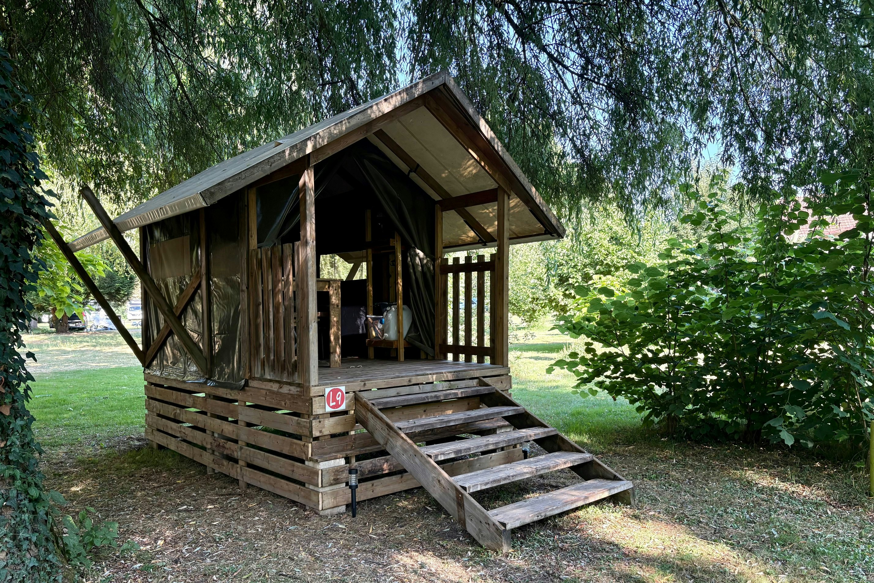 Camping Le Moulin de la Gassotte Lodge Le Baroudeur Mietunterkunft im Halbschatten unter Bäumen