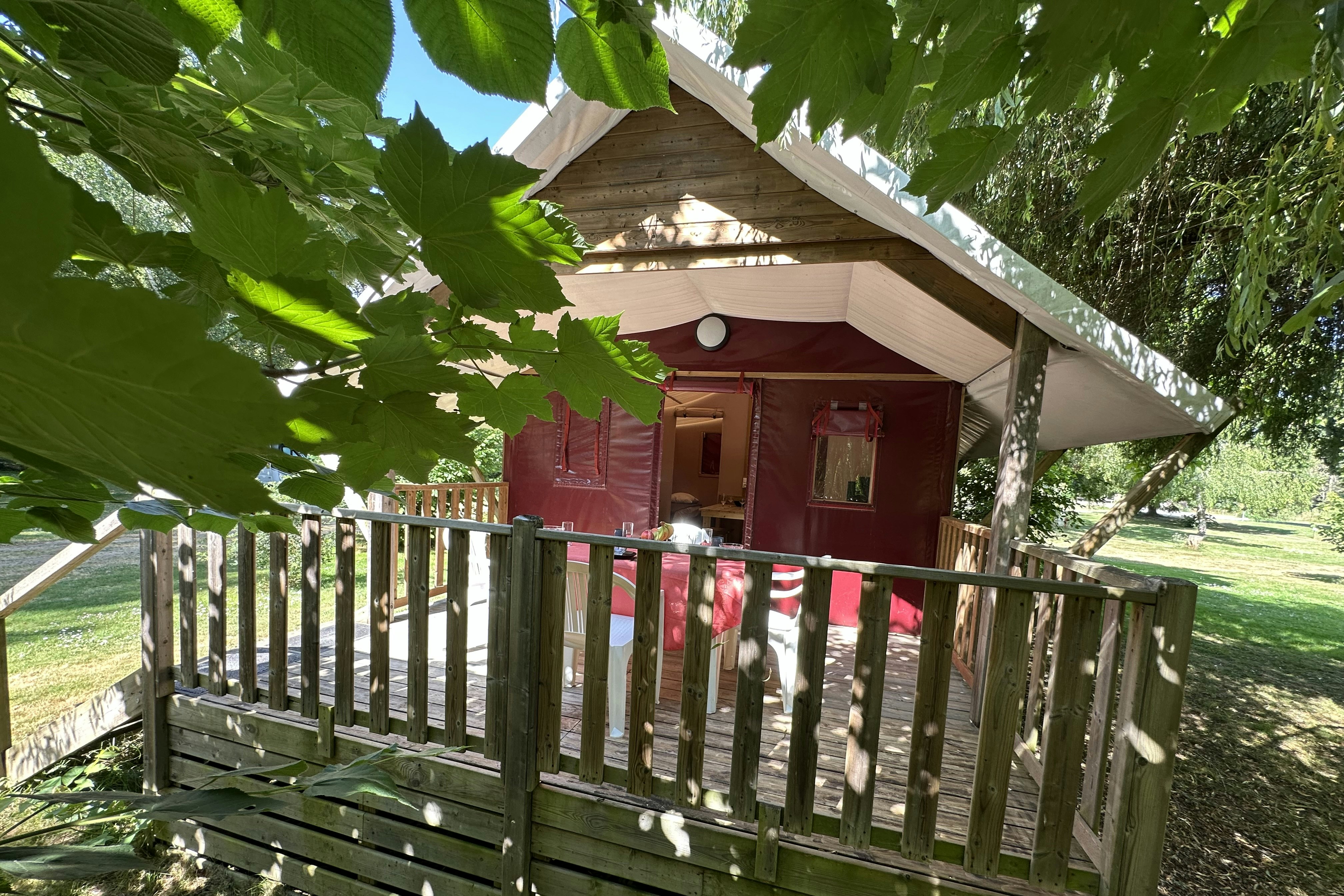 Camping Le Moulin de la Gassotte Lodge Loutre Mietunterkunft mit Veranda im Halbschatten