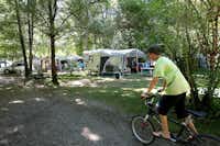 Campin le Moulin de Mellet - Kind mit Fahrrad auf dem Wohnwagen- und Zeltstellplatz vom Campingplatz