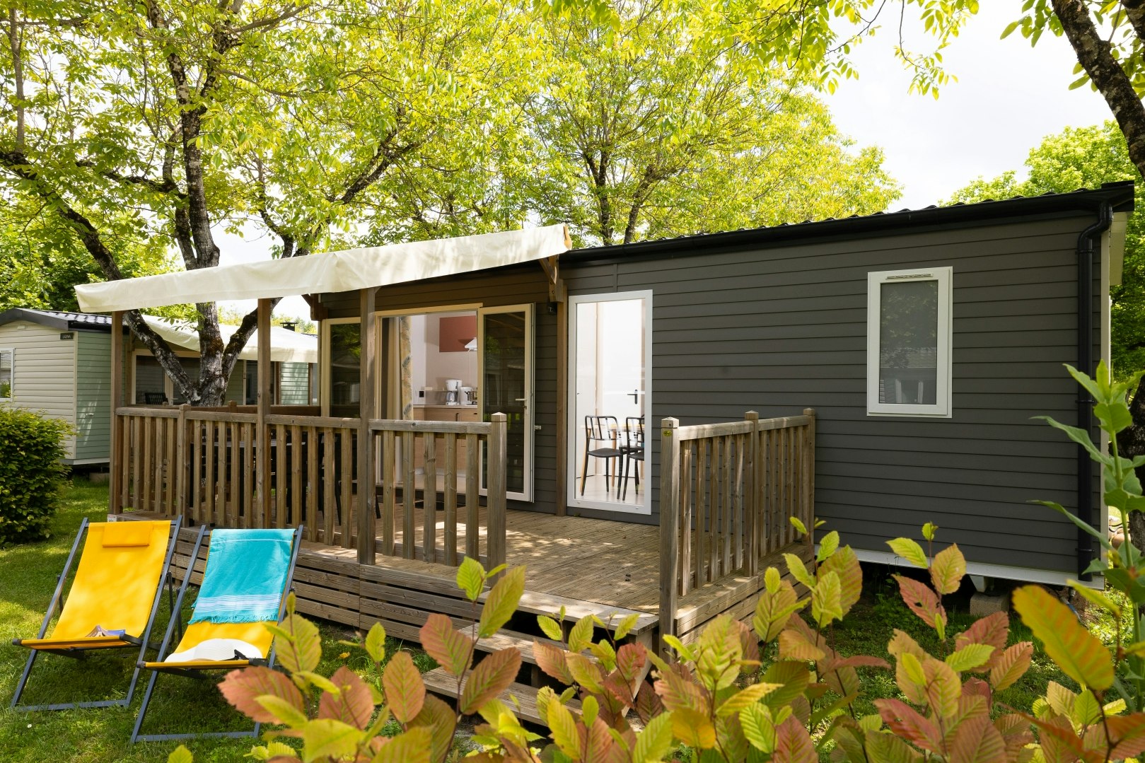 Camping Le Moulin de Paulhiac  - Mobilheim mit Terrasse auf dem Campingplatz