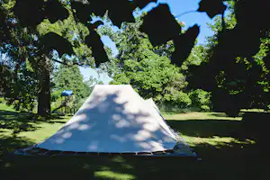 Camping Le Muret - Blick auf ein Zelt im Schatten der Bäume