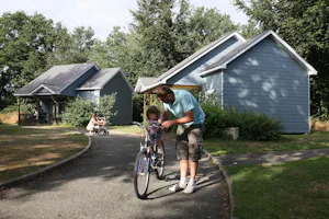 Camping Le Parc de Vaux - Chalets auf dem Campingplatz mit Campern im Vordergrund