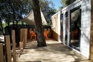 Camping Le Pastory - Veranda mit Esstisch unter einem Sonnensegel vom Mobilheim auf dem Campingplatz