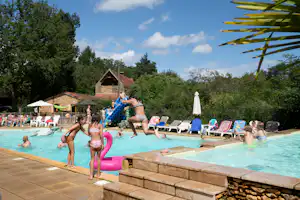 Camping Le Pech Charmant - Freibad mit Liegestühlen