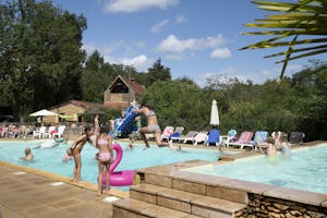 Camping Le Pech Charmant - Freibad mit Liegestühlen