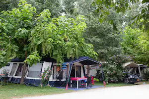 Camping Le Perpetuum - Wohnwagen- und Zeltstellplatz unter Bäumen auf dem Campingplatz
