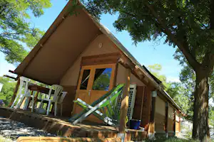 Camping Le Petit Liou - Mobilheim zwischen Bäumen auf dem Campingplatz