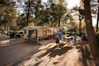 Camping Le Pianacce - Wohnwagen mit Vorzelt unter Bäumen auf dem Campingplatz