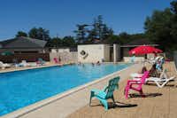 Camping Le Picouty - Swimmingpool mit Sitz- und Liegegelegenheiten und Sonnenschirm