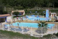 Camping Le Pilat - Swimmingpools auf dem Campingplatz mit Rutsche, Liegen am Rand und Liegewiese mit Sonnenschrimen
