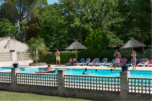 Camping Le Pilon d'Agel - Pool mit Liegestühlen und Sonnenschirmen auf dem Campingplatz