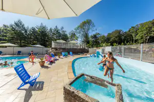 Camping Le Plô - Poolanlage mit Liegestühlen und Sonnenschirmen auf dem Campingplatz