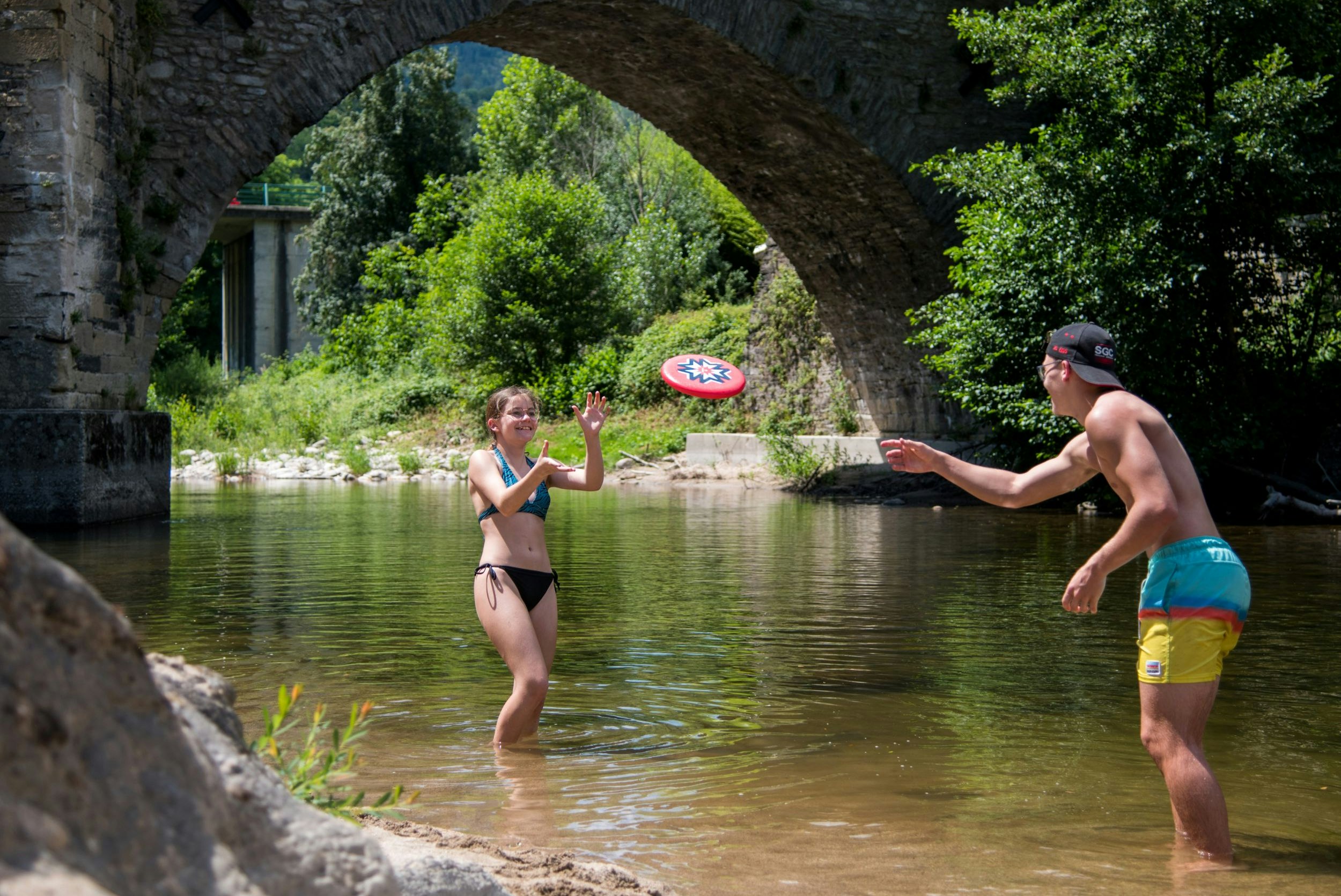 Flower Camping Le Pont du Tarn - Camper spielen Frisbee im Fluss