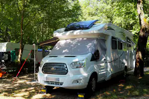 Camping Le Péquelet Wohnmobilstellplatz unter Bäumen auf dem Campingplatz