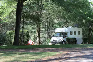 Camping Le Puech des Ouilhes - Wohnwagen- und Zeltstellplatz unter Bäumen auf dem Campingplatz