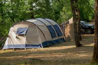 Camping Le Querce - Zelt auf einem Stellplatz unter Bäumen