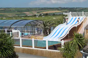 Camping Le Ranch - Poolbereich mit einem überdachten Schwimmbecken und Wasserrutschen