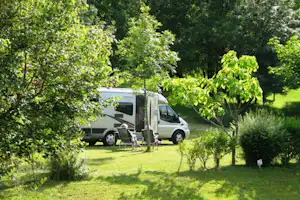 Camping Le Repaire / Camperpaar vor ihrem Wohnwagen in der Sonne