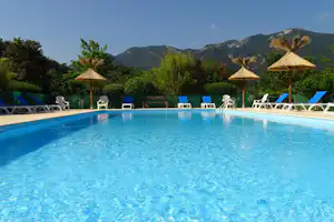 Camping Le Riou-Merle - Swimmingpool auf dem Campingplatz mit Liegen und Sonnenschirmen am Rand