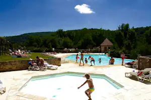 Camping Le Rocher de la Cave - Campingplatzanlage mit Pool und Liegestühlen in der Sonne