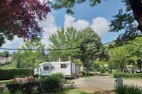 Camping Le Rouergue - geschotterter Weg des Campingplatzes and Standplätze teilweise im Halbschatten unter Bäumen