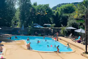 Camping Le Tiradou - Freibad mit Liegestühlen und Sonnenschirmen auf dem Campingplatz